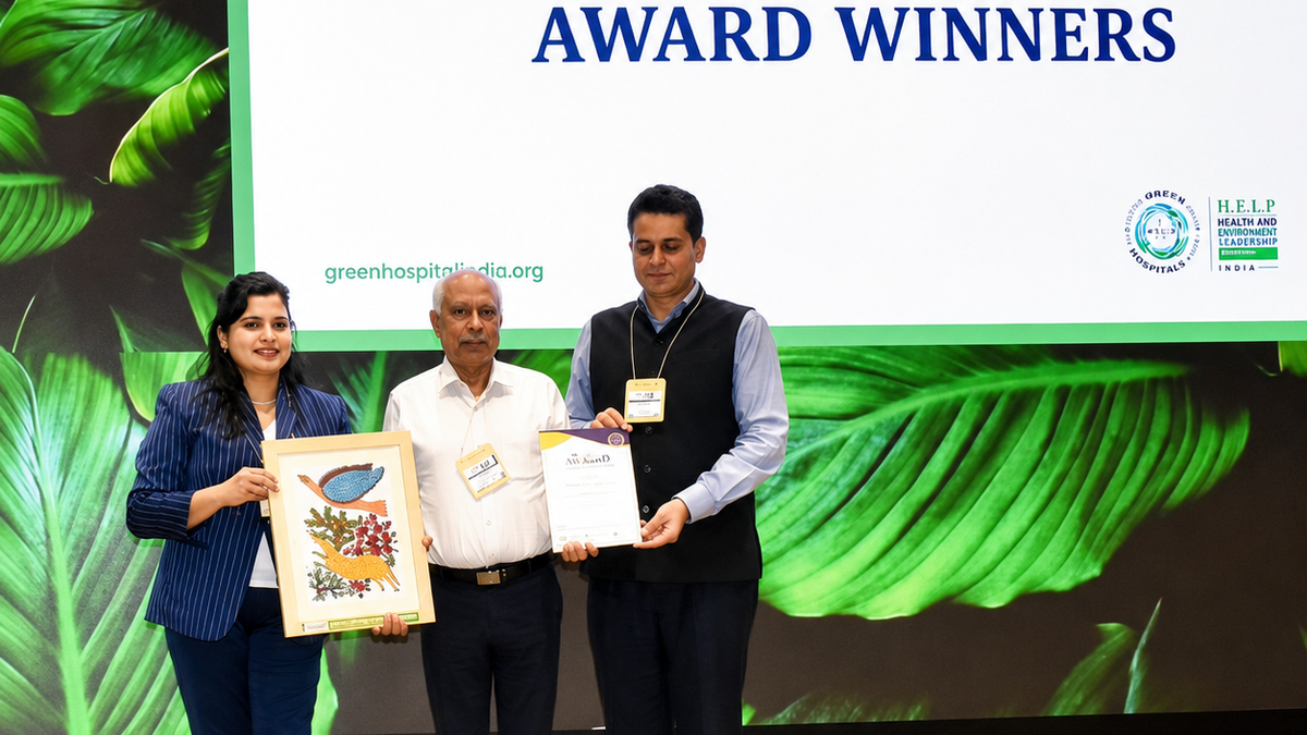 Dr. Sushil Jathanna centre accepting the HELP Sustainability Excellence Award 2026